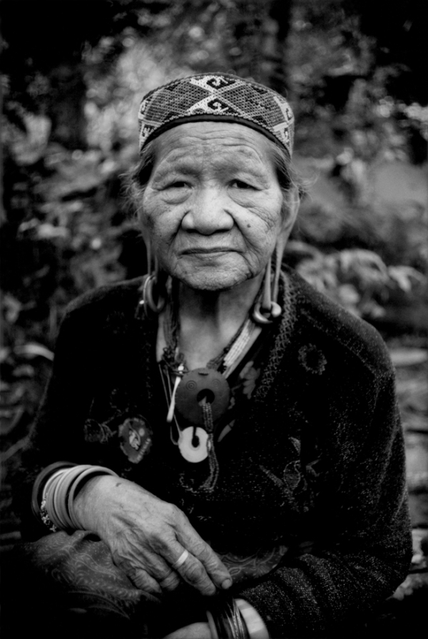 An traditional aged Penan woman in Long Kepang, Malaysia, sits in the rainforest, which is only accessible on foot.  (James Whitlow Delano) 