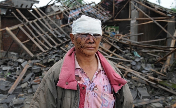 An injured man stands outside his destroyed home a day after a 7.8 magnitude earthquake hit the town of Hanwang in Sichuan Province. (Mark Ralston/AFP/Getty Images)