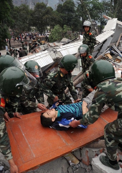 Chinese rescuers evacuate a boy from the rubble of a collapsed building in Beichuan on May 13, 2008, after an earthquake measuring 7.8 rocked southwest China&apos;s Sichuan province.