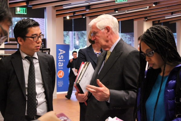Robert Hsu, Associate Director of Asia Society Northern California, welcomes ASNC member Wayne Phillips, a teacher at Millbrae High School. (Yiwen Zhang/Asia Society)