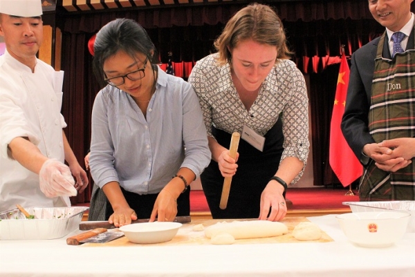 YPG member and ASNC Director of Programs, Eve Cary, receive personal assistance from the chef and Consul General Luo. (Natasha Cheng/Asia Society) 