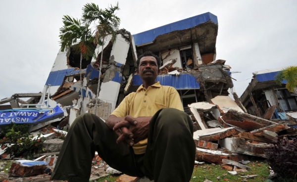 An Indonesian man sits in front of a collapsed hospital building after a 7.6-magnitude earthquake struck in Padang, West Sumatra, on October 1, 2009. At least 1,100 are dead, according to UN officials. (Bay Ismoyo/AFP/Getty Images)