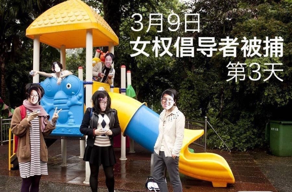Masked activists pose on playground equipment. 