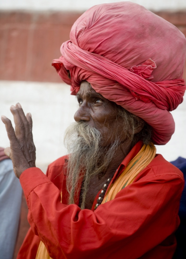 A bearded man in a red turban uses his hands to express himself in Varanasi, India on November 23, 2009. (Nancy A. Scherl)
