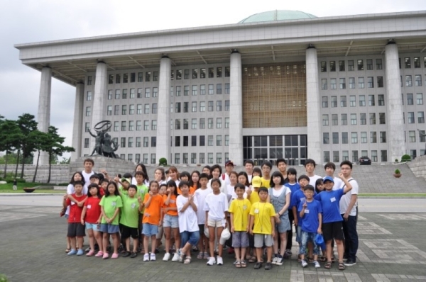 The Honorable Kyung-won Na (2nd row, center), member of the 18th National Assembly, poses for a picture with the Summer Camp participants during their visit to the National Assembly. (Asia Society Korea Center)