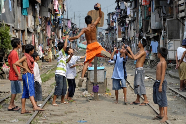 Children play basketball along railroad tracks bounded by shanty houses in Manila on March 12, 2008. (Jay Director/AFP/Getty Images)