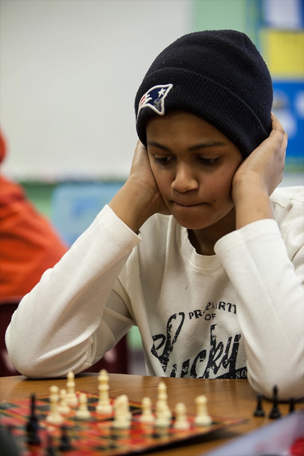 Middle school students concentrating on a chess game. Middle and high school students have an array of activities and clubs to participate in to complement their academic studies.