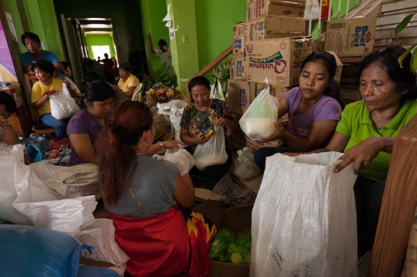 Staff from the local government packs relief goods at the municipality of Medellin, Bogo after Typhoon Yolanda.