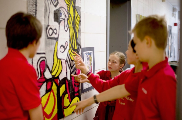 Each middle school class annually completes a large-scale collaborative painting based on a master work such as Roy Lichtenstein’s Woman with a Flowered Hat. Students use a grid system to proportionately enlarge an image. (Jennifer Hakes/Yinghua Academy)