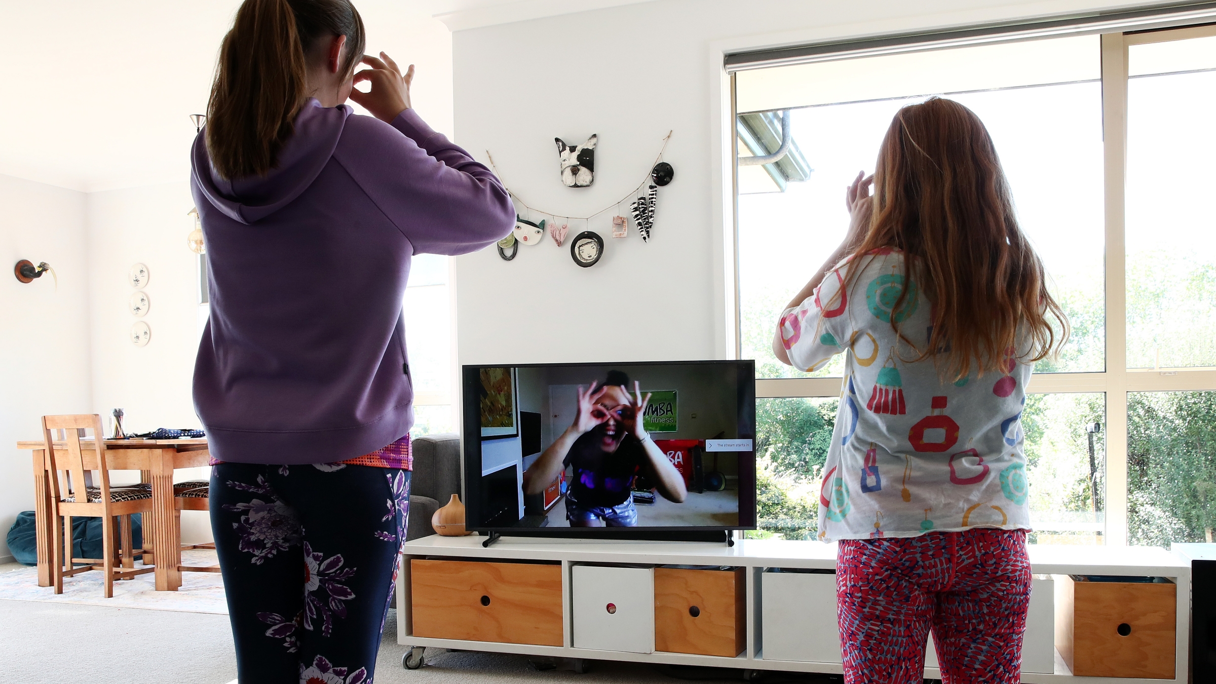 Two sisters follow a Zumba lesson online in Auckland, New Zealand, during the COVID-19 pandemic.