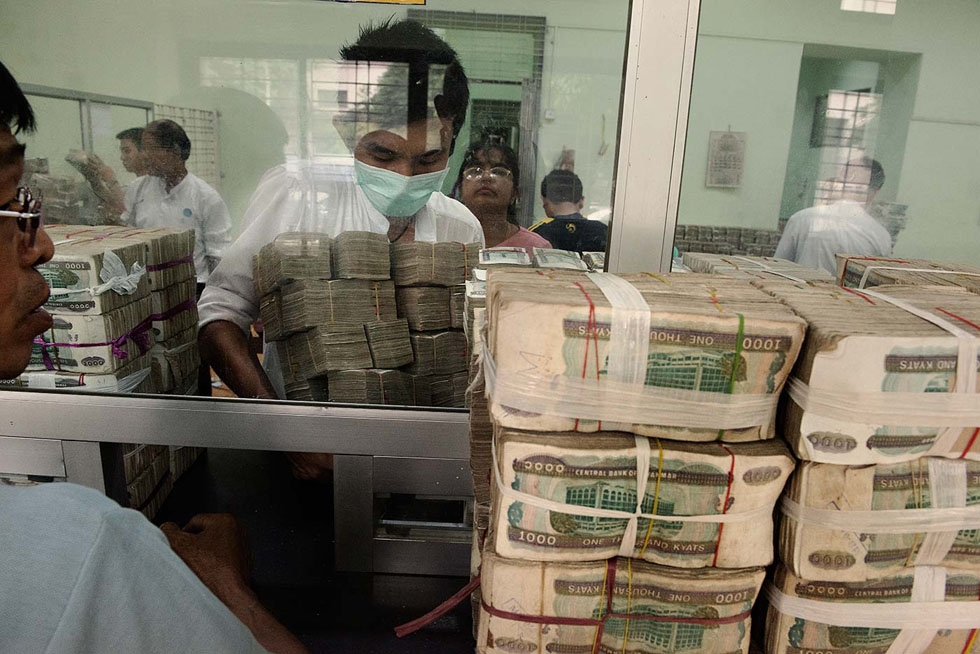 At a bank in downtown Yangon, gold and gem traders bring stacks of kyat (the local currency) to be exchanged for dollars. (Gilles Sabrié)