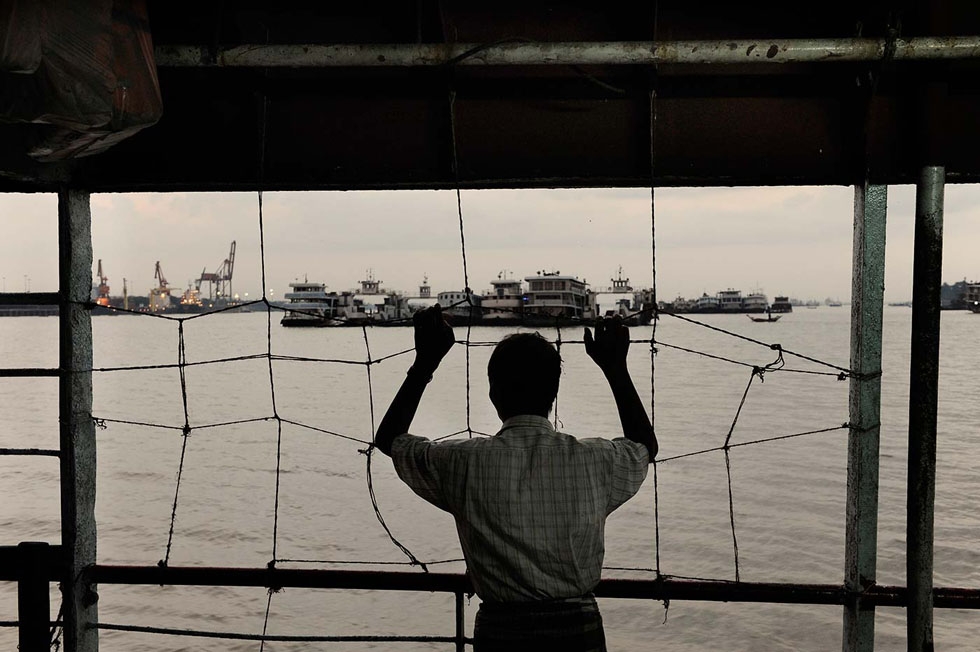 A man stares at Yangon harbor from a ferry. In spite of the reforms, Myanmar's economy is still in a dire situation. (Gilles Sabrié)