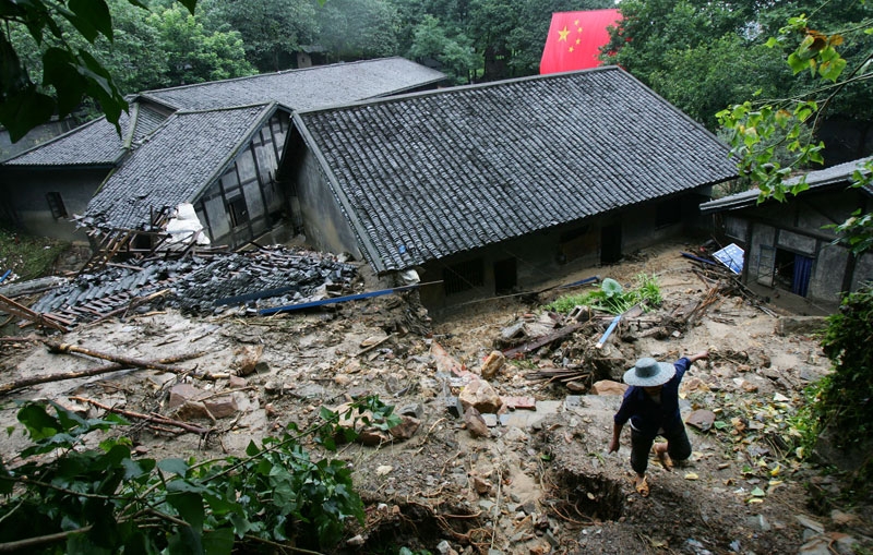 A worker passes buildings destroyed by mudflows at the memorial site of Zhazidong Prison on July 19, 2007 in Chongqing Municipality, China. (China Photos/Getty Images)