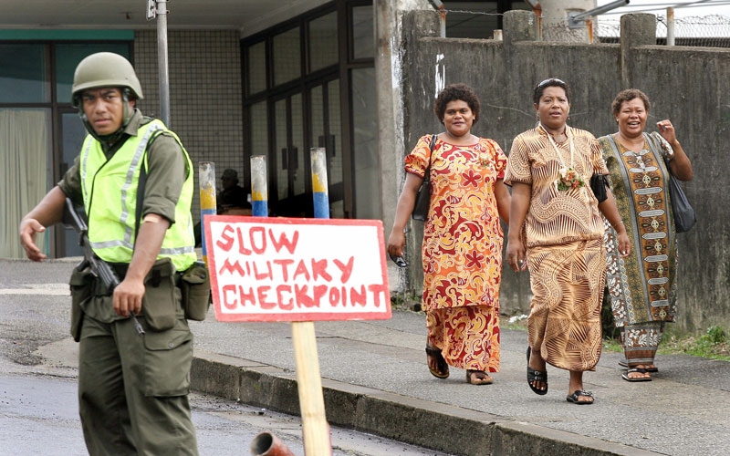 Women walk past an army checkpoint in central Suva on December 7, 2006, days after a military coup in Fiji. (William West/AFP/Getty Images) 