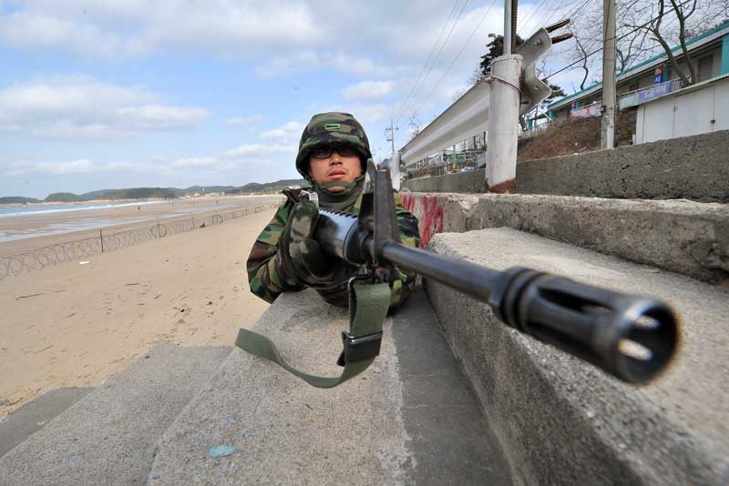A South Korean soldier stands guard as others prepare for landing operations on a beach in Taean, around 170 km southwest of Seoul on November 28, 2010. The US and South Korea staged a potent show of naval strength as residents of a border island bombarded last week by North Korea scurried for shelter for fear of a new attack. (Jung Yeon-Je/AFP/Getty Images) 