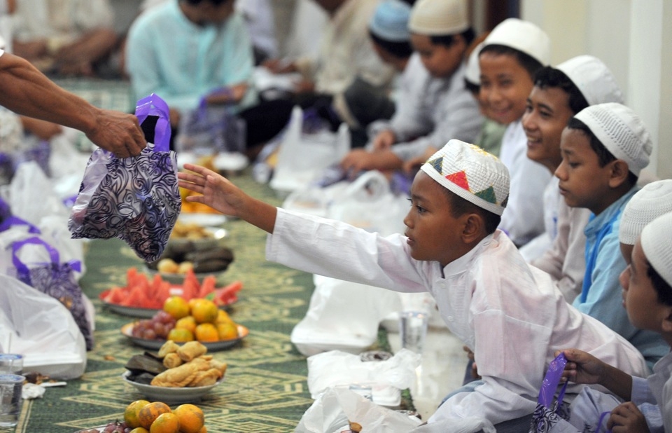 Indonesian children from poor families receive a bag of gifts before they partake in an Iftar or breaking of the fast with fruits, rice cakes, water, and juice at Darussalam mosque in central Jakarta on September 5, 2010. (Romeo Gacad/AFP/Getty Images)