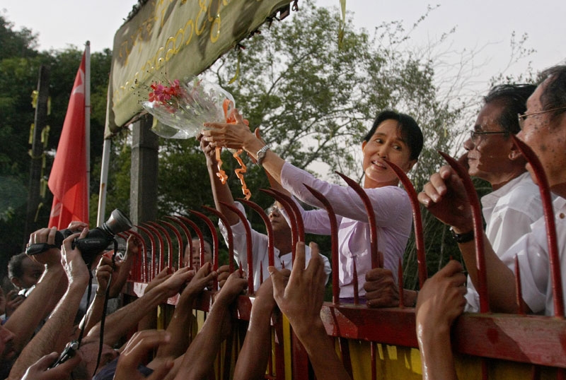 Burma/Myanmar's detained opposition leader Aung San Suu Kyi holds a bouquet of flowers as she appears at the gate of her house after her release in Yangon (Rangoon) on November 13, 2010. The lakeside home had been her prison for most of the past two decades. (Soe Than Win/AFP/Getty Images)
