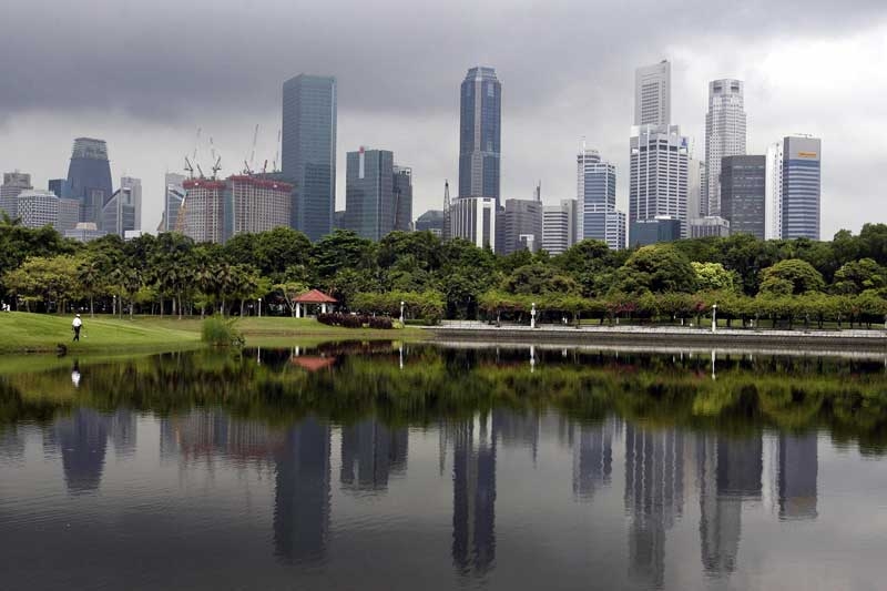 Skyscrapers are reflected on a man-made lake as a cloud hovers overhead in Singapore in Apr. 2007. Desalination and recycled water are key to addressing the world's growing thirst for the precious resource, officials said here. (Roslan Rahman/AFP/Getty Images)