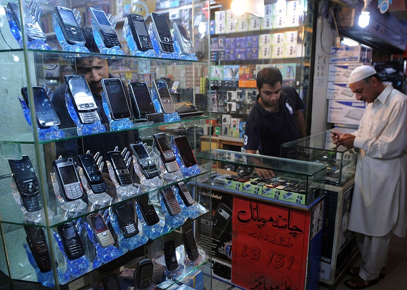 A Pakistani mobile seller shows phones to a customer at a Lahore electronics market in 2010. As of late 2011, Pakistan is estimated to have 100 million cell phone users. (Arif Ali/AFP/Getty Images) 