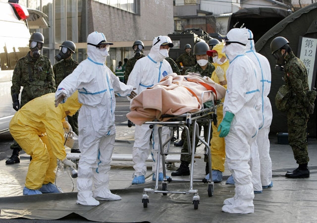 Real-life persons of the year? Rescue workers carry someone believed to be contaminated with radiation to a treatment center in Nihonmatsu city in Japan's Fukushima prefecture on Mar. 13, 2011. (Jiji Press/AFP/Getty Images) 