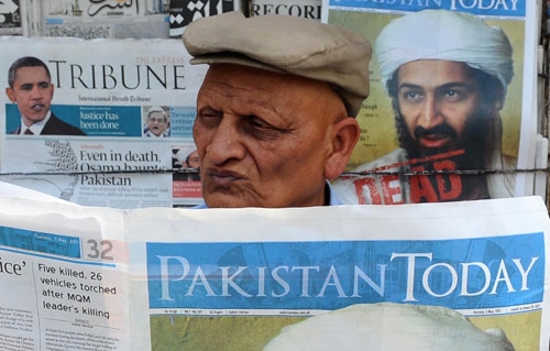 A Pakistani man reads a newspaper with the front page displaying news of the death of Osama bin Laden at a stall in Lahore on May 3, 2011. (Arif Ali/AFP/Getty Images)
