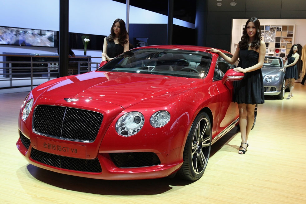 Models stand beside the Bentley Continental GT V8 car during the 2012 Beijing International Automotive Exhibition at China International Exhibition Center on April 25, 2012 in Beijing, China. (Feng Li/Getty Images)