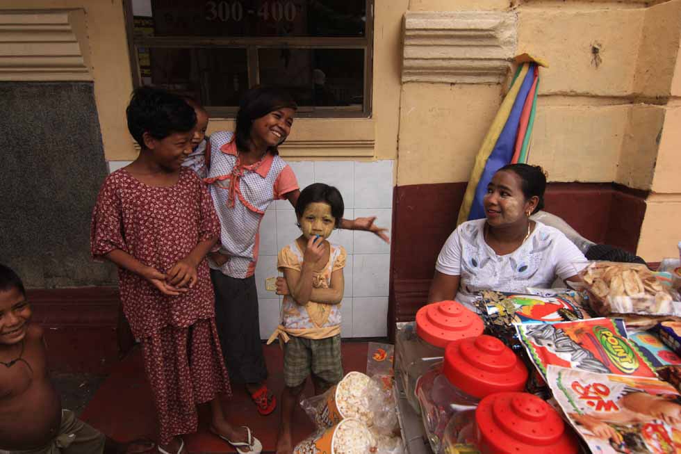 Children of street vendors play in front of the Waziya Cinema in Yangon, Burma. (Philip Jablon)