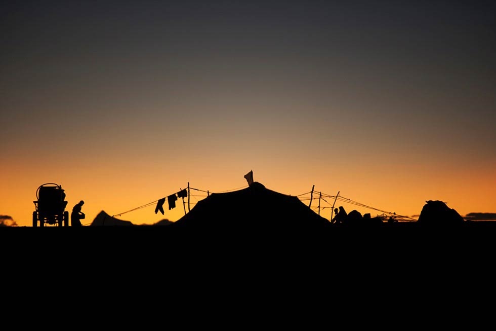 Silhouetted against the morning sunrise, a nomad encampment is situated along Route 109, near Namtso Lake. (Michael Yamashita)