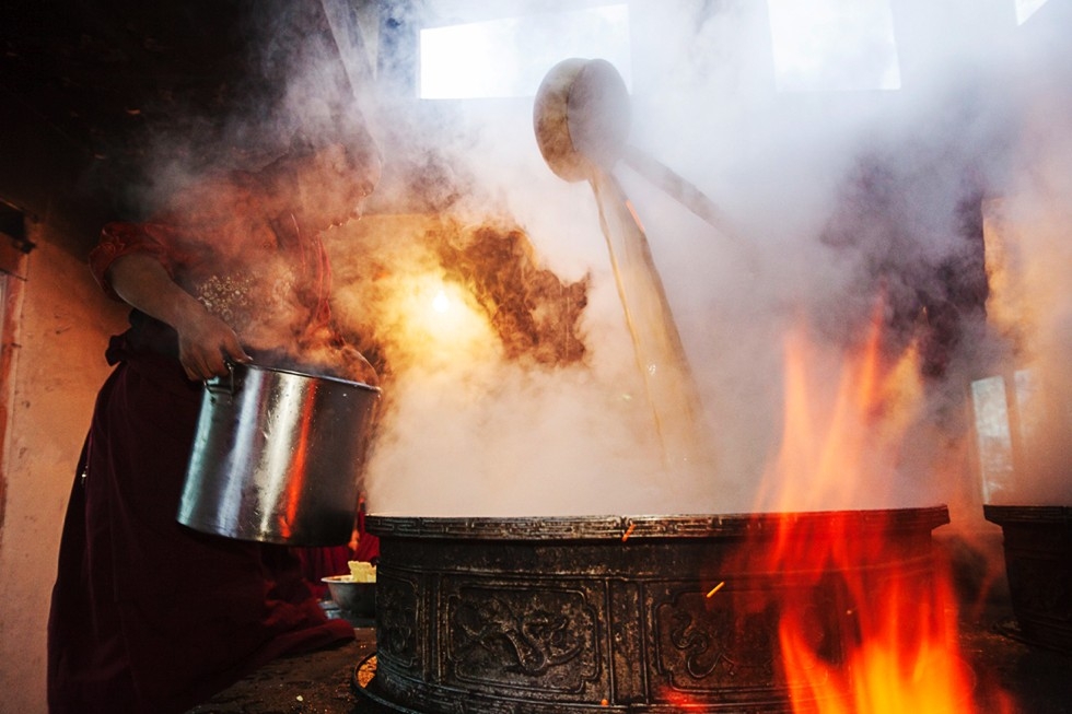 A steaming cauldron of yak butter tea will serve 800 monks at Shechen Monastery. (Michael Yamashita)