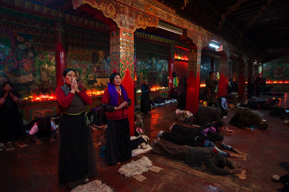 Locals, who have been invited to Garthar Monastery during a festival, engage in the various stages of the highly ritualized practice of prostration called Chak Tsal, which means "to sweep clean." (Michael Yamashita)