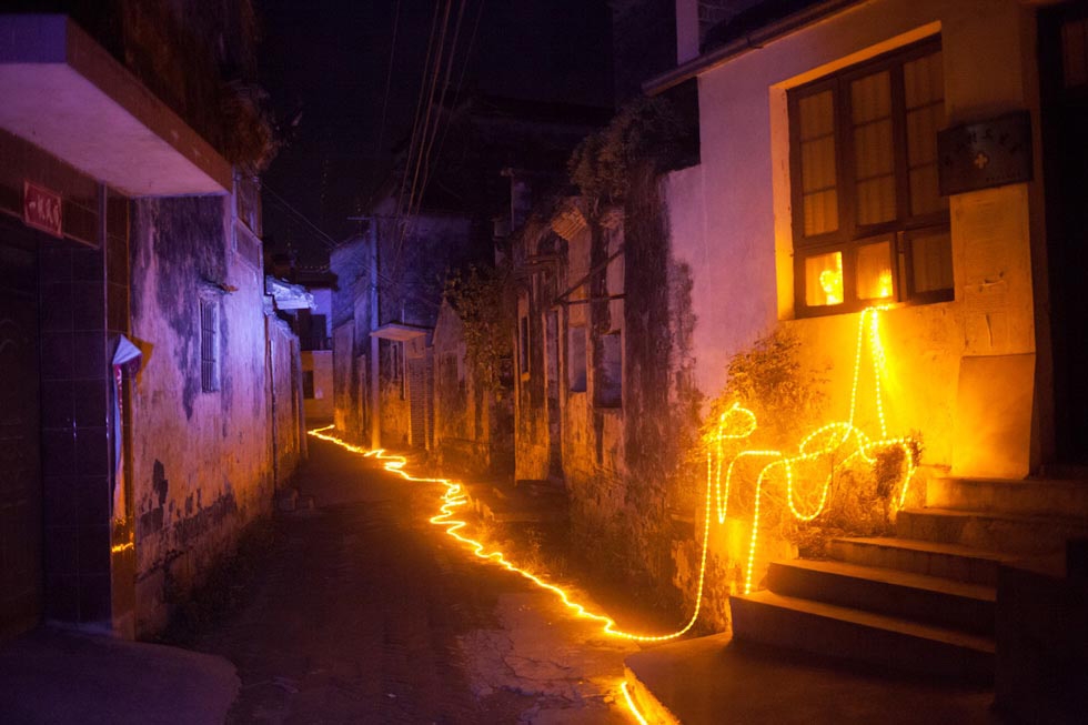 A string of LED lights designed for the Harvestival by Taiwanese architect Teng Hai lit the alleyways of Bishan, providing the village with its first street light. The light remained on for three days before it was ordered turned off. (Leah Thompson)