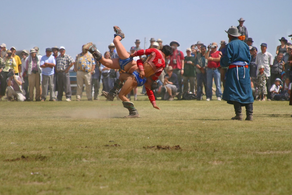 A wrestling match occurs in an open field as part of the Naadam festival. (Emilia Tjernström/Flickr)