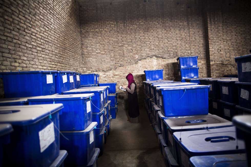 Afghan election employee Forouzan Barez checks the plastic boxes containing election material at a warehouse prior to transportation to the polling centers in Herat on April 3, 2014. (Behrouz Mehri/AFP/Getty Images)