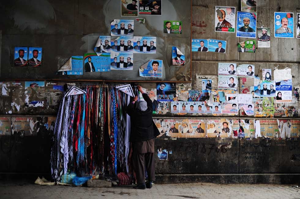 An Afghan roadside vendor hangs scarves next to political leaflets on a wall in Kabul on April 4, 2014. Some 12 million Afghans will go to the polls on April 5 to elect a new President. (Roberto Schmidt/AFP/Getty Images)