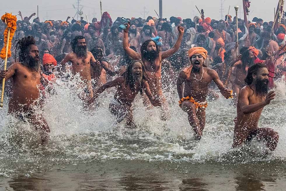 Naga sadhus run in to bathe in the waters of the holy Ganges river during the auspicious bathing day of Makar Sankranti of the Maha Kumbh Mela on January 14, 2013 in Allahabad, India. (Daniel Berehulak/Getty Images)