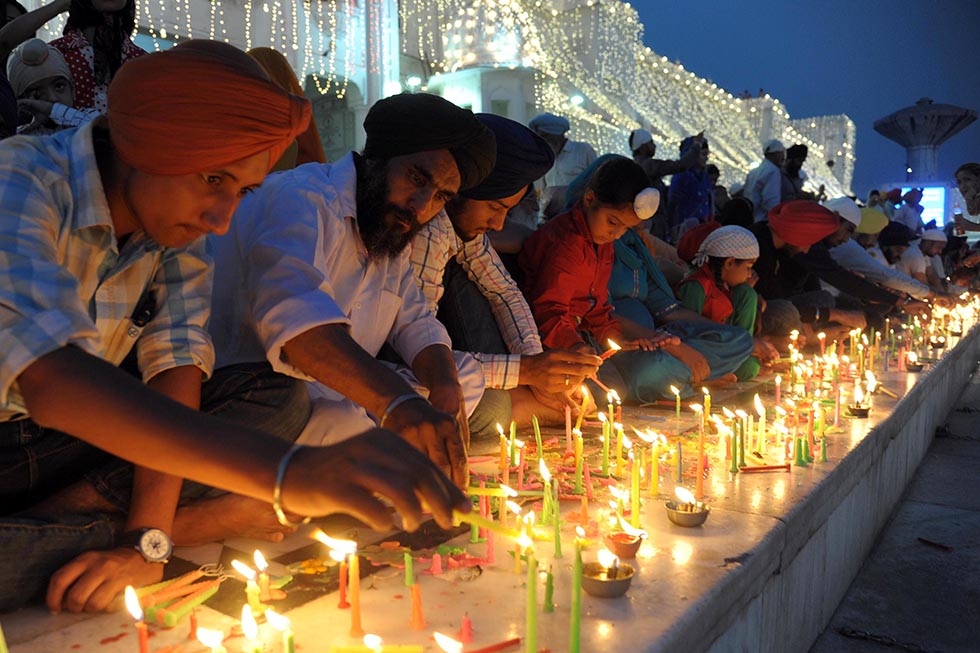 Indian Sikh devotees light candles during Diwali at the illuminated Golden Temple in Amritsar, India on October 23, 2014. (Narinder Nanu/AFP/Getty Images)