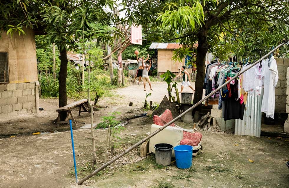 Sunday is Wash Day and hoops for the men. There are no water mains in this village. Water is collected from deep wells by manual water pumps. Cebu, Philippines. (Richard James Daniels)