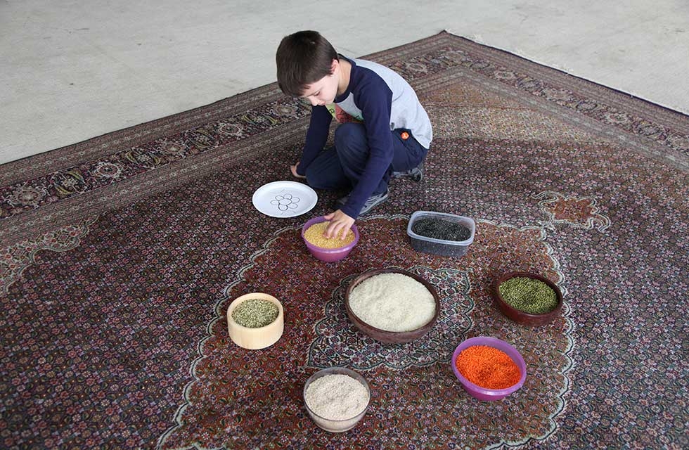 A child collects materials to create rangoli, patterned floor decorations which are thought to bring luck, on October 15, 2016 in New York. (Ellen Wallop/Asia Society)