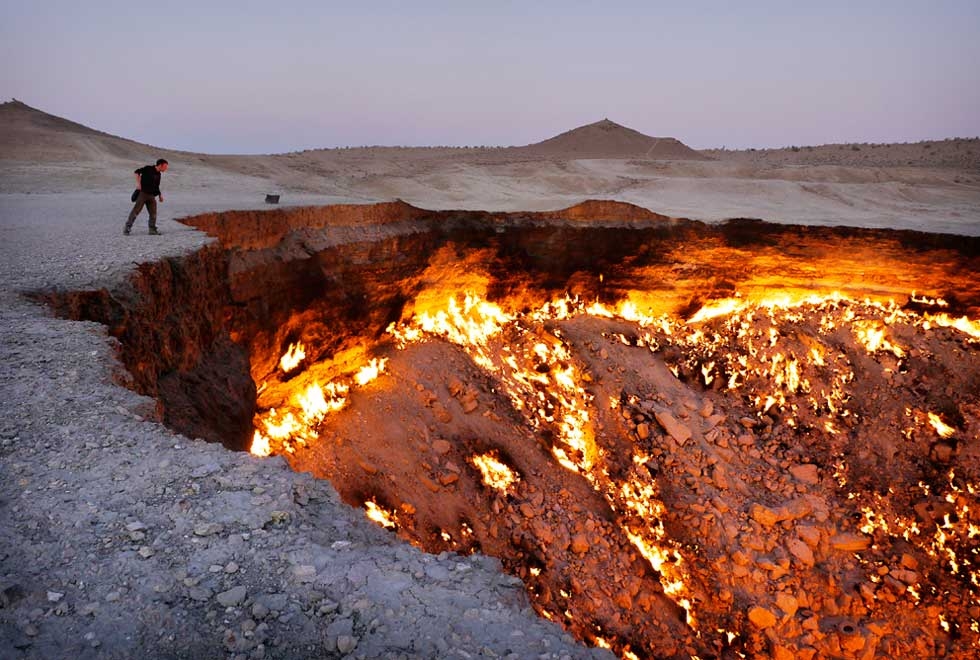 The Darvaza gas crater in the desert of Turkmenistan. In the 1970s the Soviets were drilling for gas and collapsed this crater. The huge outpouring of gas posed a danger for nearby villages so the crater was lit, and has been burning ever since. (Amos Chapple)
