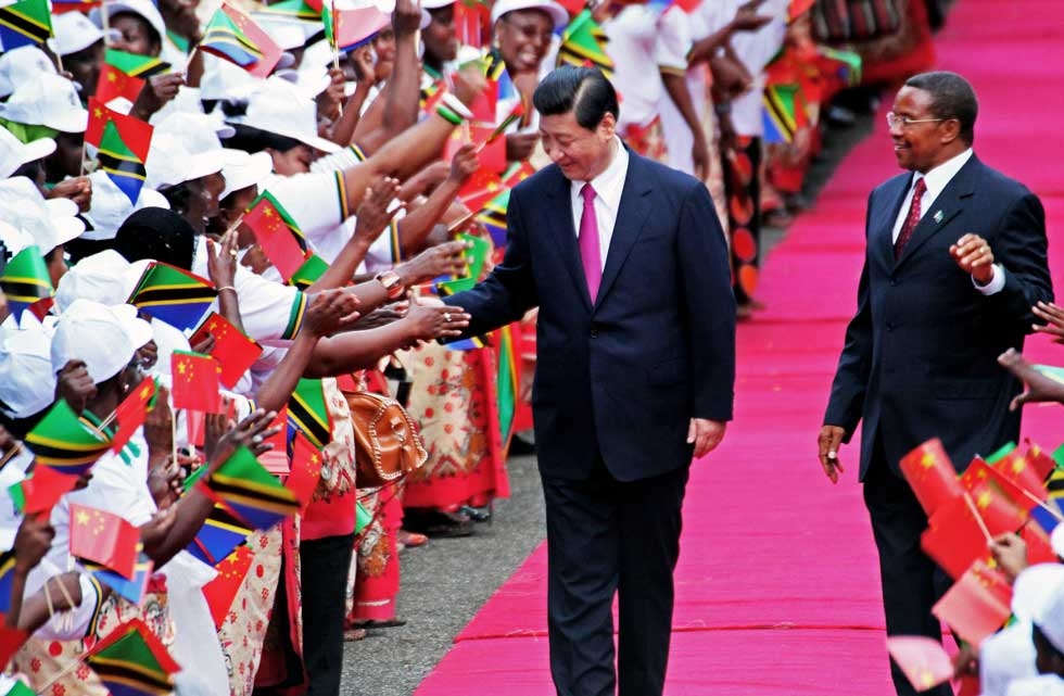 Chinese President Xi Jinping (L) shakes hands with members of a welcoming committee eyed by Tanzanian President Jakaya Kikwete (R) upon Xi's arrival at Julius Nyerere International Airport. (John Lukuwi/AFP/Getty Images) 