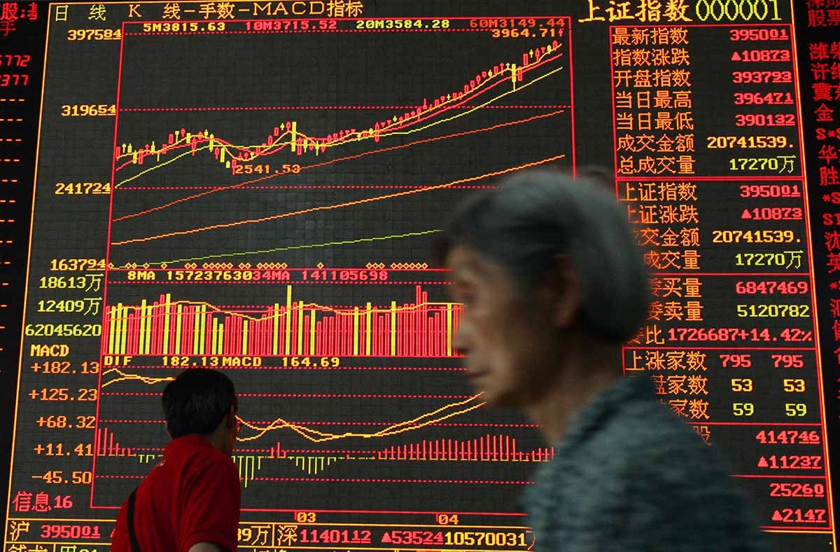 An investor walks past an electronic screen displaying stock index at a securities company in Wuhan, China. (China Photos/Getty)