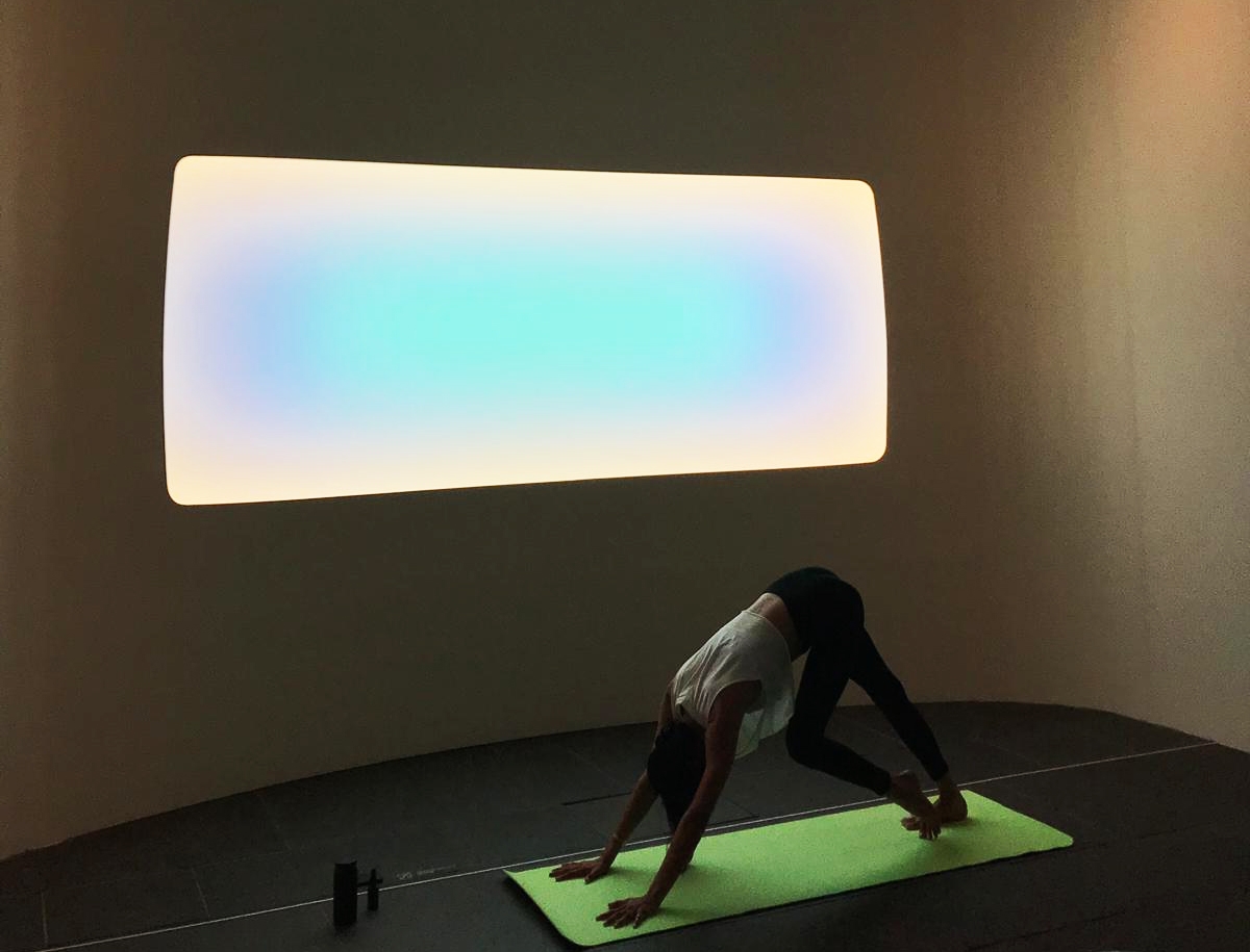 Person doing yoga on mat in front of Yukaloo by James Turrell.