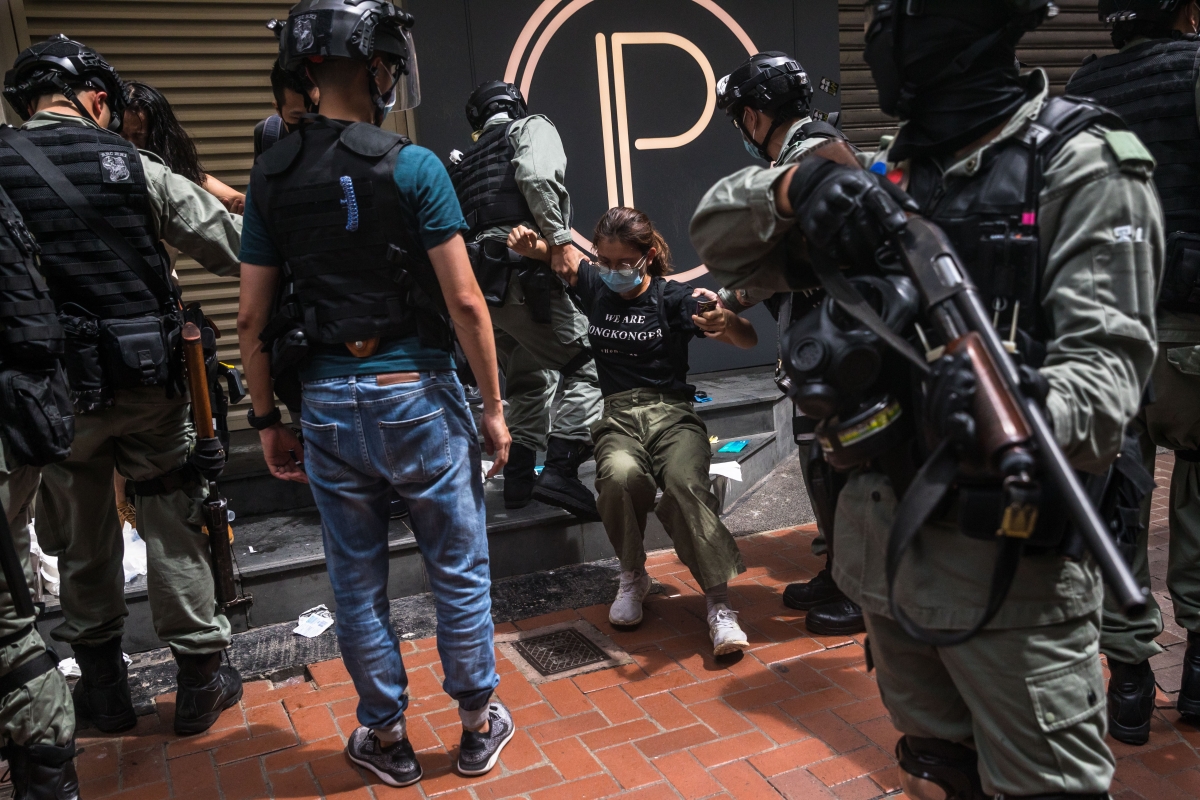 Riot police detaining a woman as they clear protesters taking part in a rally against a new national security law in Hong Kong.