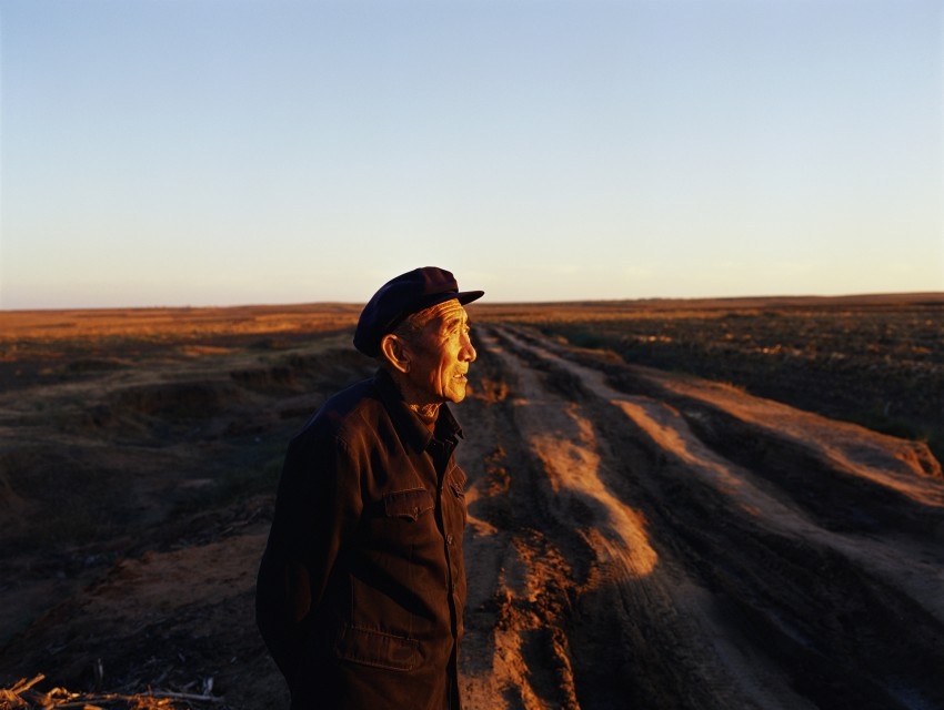 An elderly man looks towards the sunset