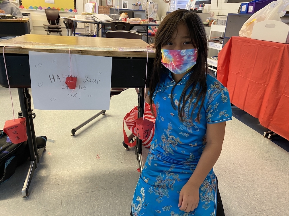 Third-grader wearing Chinese traditional costume making the Chinese Lantern on the Lantern Festival day