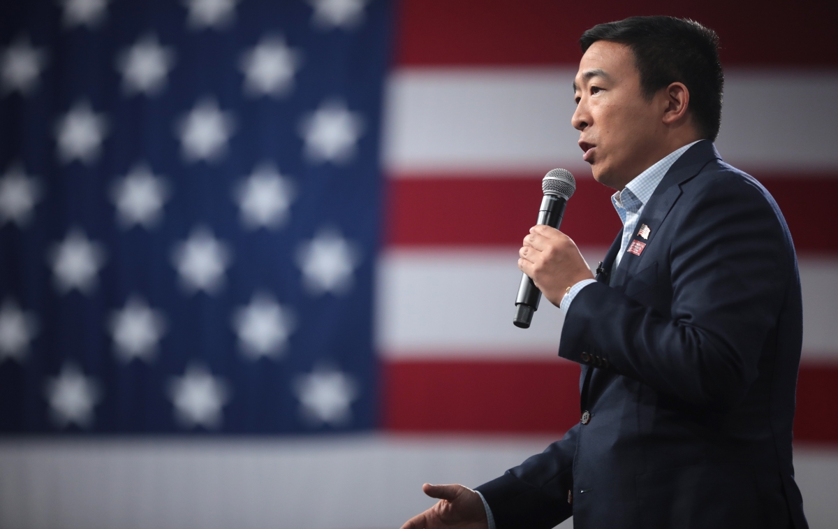 Andrew Yang delivering a speech in front of the American flag