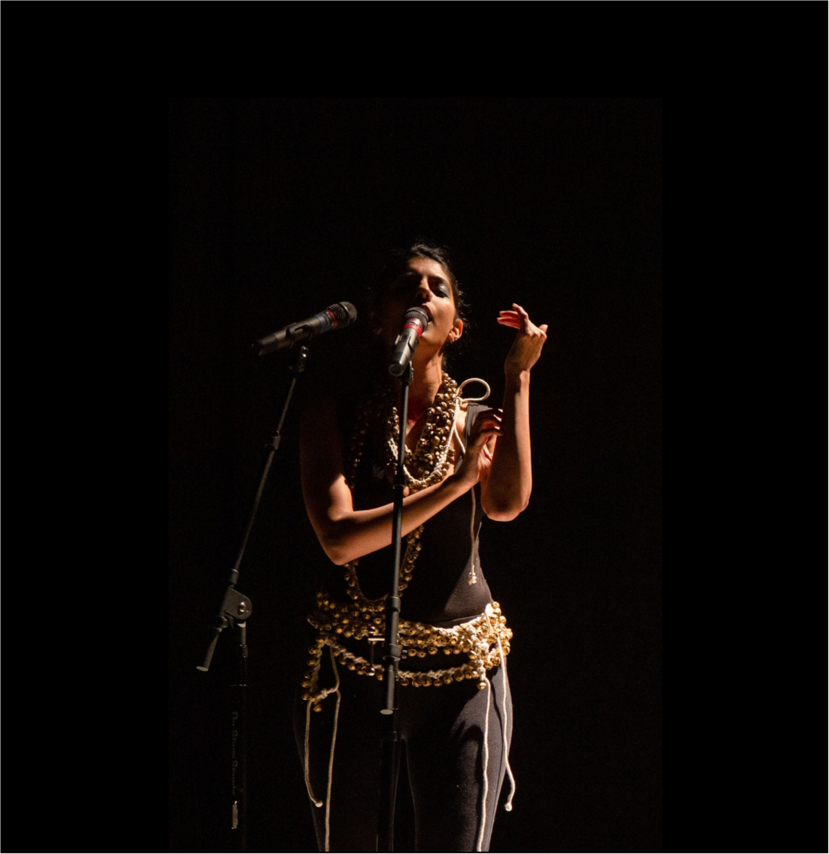 Photo of artist Samita Sinha singing in her performance Kaalo Jol. 