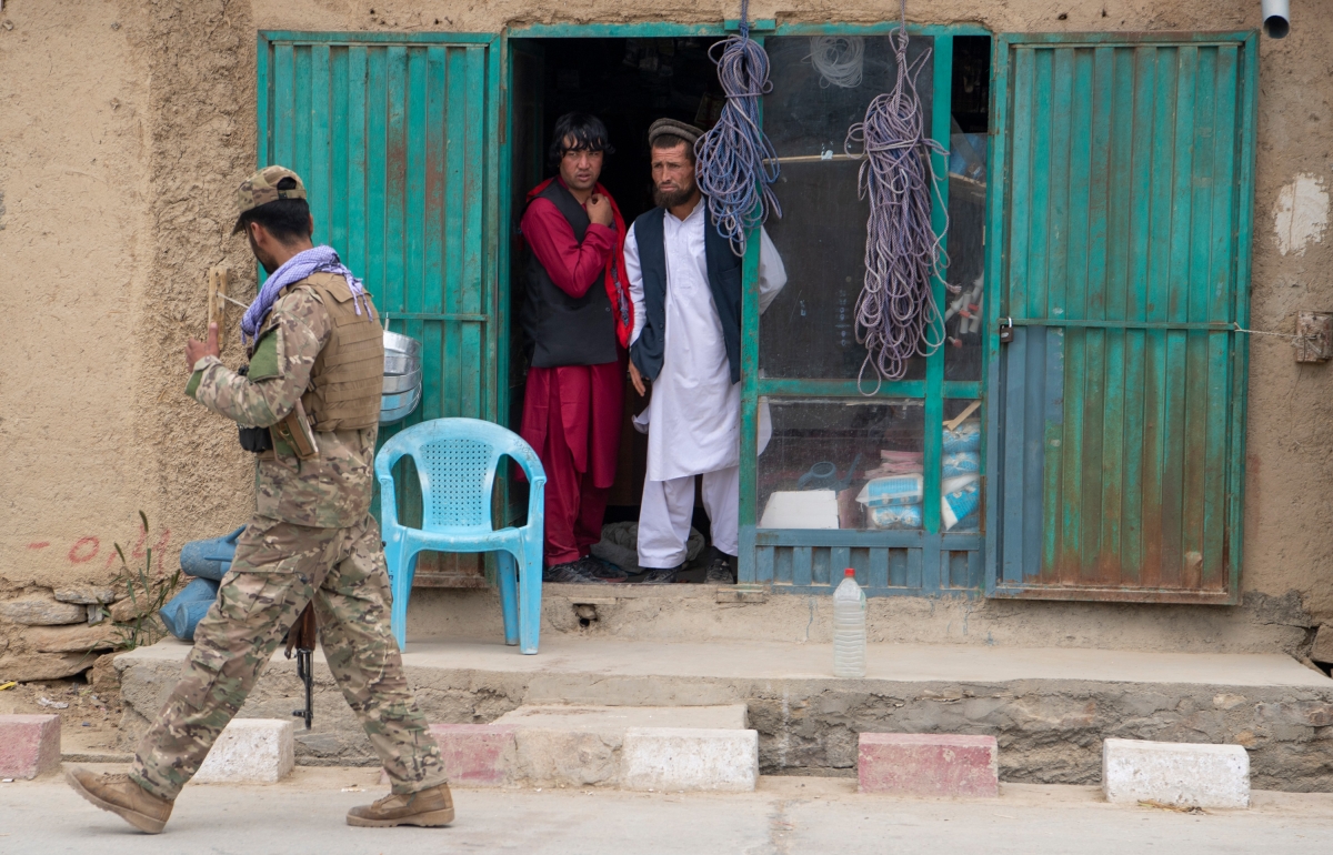An Afghan military policeman walks past a local shop in Saighan district on July 21, 2021