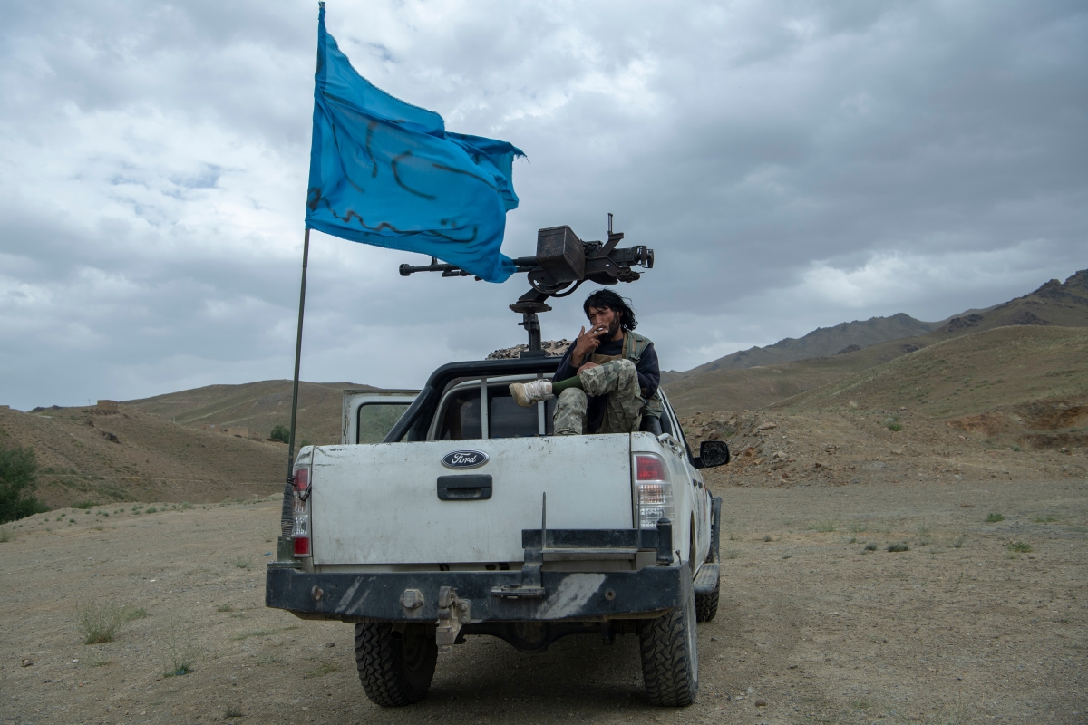 A militia member from Afghanistan's Hazara ethnicity, a group that faced extreme persecution under the previous era of Taliban rule, smokes a cigarette while on patrol in Wardak province, central Afghanistan, on July 19, 2021.