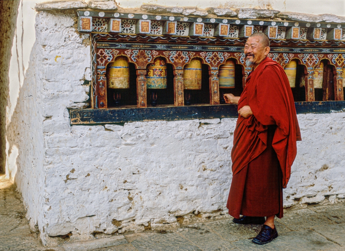 A Bhutanese monk spins a prayer wheel
